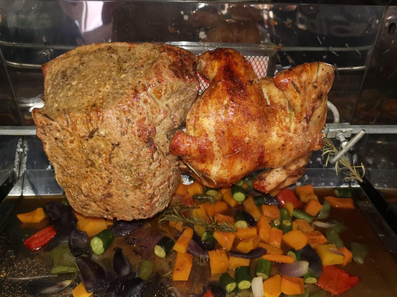 Crisped beef and chicken above a tray of roast vegetables